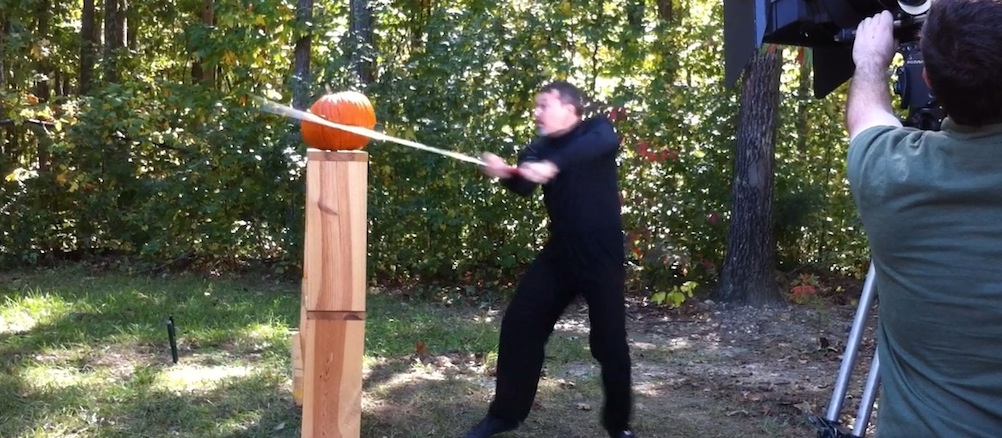 cutting a pumpkin with a medieval sword